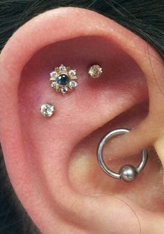 an ear with three piercings attached to it's side, and two smaller ones behind the ear