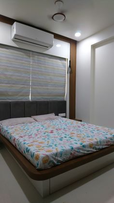 a bedroom with a bed and air conditioner in it