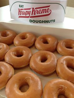 glazed doughnuts in a box with krispy kreme's logo