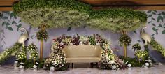 an arrangement of flowers, plants and birds is displayed on the wall behind a bench