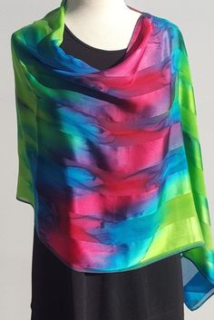 "This sconcho is a versatile piece for everyday wear or for an elegant evening out. It was created out of satin striped silk, then hand painted with jewel tones of every color in the rainbow. It shimmers and looks lovely with so many things. Flowey \"poncho like\" accessory to brighten up your day! Wear over your head with the seam in the back for a symmetrical look or with the seam on the shoulder for an asymmetrical thinning effect as a poncho. The Sconcho can also be put around your neck and Multicolor Silk Scarf For Spring Party, Multicolor Silk Scarf For Party In Spring, Multicolor Silk Scarf For Evening, Multicolor Satin Silk Scarf For Summer, Silk Satin Scarf For Summer Evenings, Summer Multicolor Satin Silk Scarf, Summer Party Satin Silk Scarf, Summer Evening Satin Silk Scarf, Multicolor Silk Scarf For Party