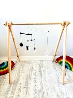 a child's play area with swings and rainbow rugs in the corner on the floor