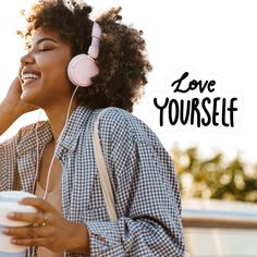 a woman wearing headphones and holding a cup with the words love yourself on it