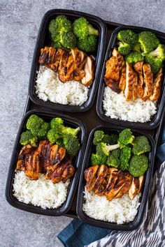 four plastic trays filled with chicken, broccoli and rice on top of a blue towel