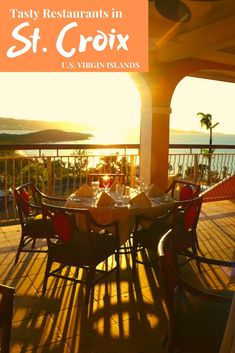 an outdoor dining area with tables and chairs on the deck overlooking the ocean at sunset