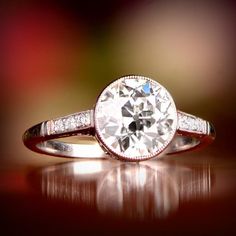 an engagement ring with a round diamond surrounded by pave diamonds on a shiny surface