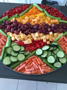 a platter filled with lots of different types of vegetables and fruit on top of each other