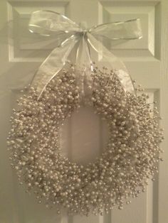 a white wreath hanging on the front door