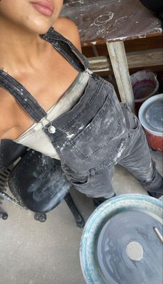 a woman sitting on the ground next to some buckets