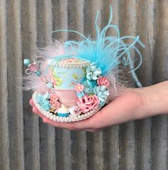 "THIS IS A MICRO MINI HAT...it will fit in the palm of your hand. A spot of tea? Perhaps a wee little cupcake. You'll get both on this little pretty fabric hat. The paper flower bouquet and lovely feathers add that extra feminine charm. Perfect for tea party atire. --------------------------------------------------------------------------- An elastic band is attached to keep it on your head. The band is meant to go behind your ears and rest at the nape of your neck (NOT UNDER YOUR CHIN). A few h Handmade Whimsical Mini Hat With Curved Brim, Handmade Costume Hats And Headpieces For Kentucky Derby, Whimsical Brimmed Hats As Gifts, Cute Mini Hats With Curved Brim As Gifts, Whimsical Curved Brim Hat, Whimsical Fascinator For Kentucky Derby Gift, Whimsical Handmade Costume Hats And Headpieces As Gift, Whimsical Handmade Brimmed Mini Hat, Whimsical Handmade Flower Costume Hat For Garden Party