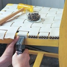 a hand holding a cell phone next to a chair with buttons on the back and seat