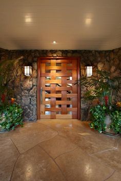 an entrance to a house with stone walls and plants