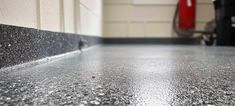 a close up view of a shiny surface in a room with white walls and black flooring