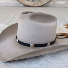 This 1/2 inch thick leather hatband is decorated with oval metal conchos. It is adjustable with a leather string tie. Made in the USA Soft Genuine Leather *This product is for 1 single hat band. Hat not included. Black Leather Hat, The Bandit, Leather Hat, Leather Hats, Leather Silver, Hat Band, Austin, Genuine Leather, Black Leather