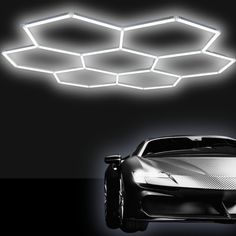 a futuristic car is shown in front of a black background with hexagonal lights