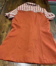 This is a 1976 Rare McDonalds Employee Uniform. It comes with the shirt, Apron, Name Tag, and Hat all from 1976. The Hat is One Size Fits All, The shirt is a size 14 and measures approx. 17 inches across from armpit to armpit. The apron is marked Style 3200 Short. The name tag is left empty so any name can be put on it. All good clean condition. Check put the photo's. These are rare and hard to find, especially like this one. The uniform was designed by Stan Herman for McDonalds. If you have any Fitted Orange Tops For Work, Fitted Orange Shirt For Workwear, Fitted Collared Orange Top, Fitted Orange Collared Top, Mcdonalds Employee, Shirt Apron, Employee Uniform, Name Tag, Put On