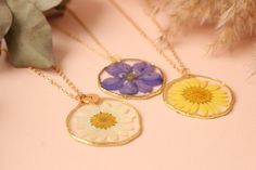 Fancy Pressed Flower Necklace Brand Fancy Material(s) Gold Plated Brass Size(s)/Dimensions(s) Circle Diameter: 36mm Made in Armenia Shipped from United States Unique necklace made from real flowers and clear resin.Unique and delicate gift idea for her.The petals have been carefully preserved to retain their color but please take care to keep this piece dry. NO LETTER CHARM INCLUDED. FOR LETTER CHARM, PLEASE CONTACT US. Gold Jewelry With Floral Print For Gift, Elegant Floral Print Jewelry As Gift, Elegant Floral Print Jewelry For Gift, Round Floral Print Jewelry For Gift, Floral Print Round Jewelry Gift, Floral Print Round Jewelry For Gifts, Round Floral Print Jewelry Gift, Floral Print Flower-shaped Jewelry Gift, Floral Print Flower Shaped Jewelry Gift