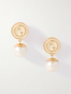 Gucci’s ‘Blondie’ earrings are brimming with vintage charm. Made in Italy from gold-tone metal, they're decorated with glossy enamel featuring the signature interlocking 'GG' motif. Lustrous faux-pearl pendants dangle from the base. Gucci Pearl Earrings, Gucci Luxury Drop Earrings, Designer Gold Drop Pearl Earrings, Designer Gold Pearl Drop Earrings, Elegant Gold Earrings With Logo Charm, Luxury Gold Earrings With Logo Charm, Vintage Gold Gucci Jewelry, Vintage Gucci Gold Jewelry, Luxury Gucci Yellow Gold Earrings