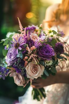 a bride holding a bouquet of purple flowers