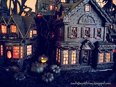 a group of halloween houses with pumpkins and lights