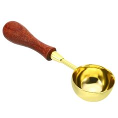 a golden measuring cup with a wooden handle