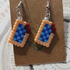 a pair of earrings made out of legos sitting on top of a piece of paper