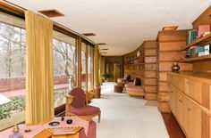 a large room with lots of windows and wooden furniture on the floor, along with bookshelves