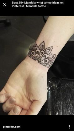 a woman's hand with a small tattoo on the wrist and an intricate design