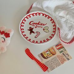 a white plate with a red bow next to a stuffed animal