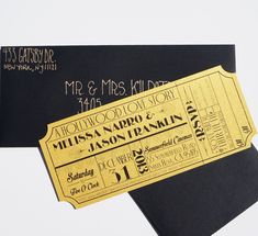 two black and gold ticket style wedding cards