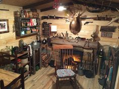 a room filled with lots of wooden furniture and deer head mounted to the wall next to a fire place