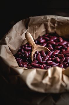 a wooden spoon in a bag filled with beans