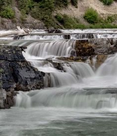 the water is flowing down the rocks in the river