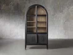 an arch shaped bookcase with wooden shelves and metal handles, in front of a concrete wall