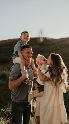 a man and woman are holding their baby in the air as they laugh at each other