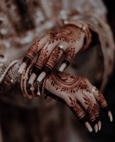 a woman's hands with hennap and rings