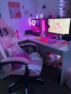 a pink and white computer chair sitting in front of a desk with two monitors on it