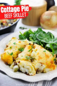 cottage pie beef skillet on a white plate with spinach and onions in the background