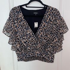 Nwt Express Printed Wrap Front Ruffle Sleeve Top In Black Print Cropped Blouse, Size Xs New With Tags, No Visible Flaws - Cropped Length - Animal Print Pattern - V-Neck Style - Short Ruffle Sleeves - Polyester Blend - Straight Hem - Smocked Back Detail - Colors: Black, Orange, White, Cream, Tan, Brown Measurements Available Upon Request Chic Orange Ruffled Top, Orange V-neck Blouse With Ruffles, Fitted Orange Tops With Ruffles, Black Cropped Blouse With Ruffles, Army Green Blouse, White Polka Dot Top, Lace Trim Blouse, Animal Print Pattern, Ruffle Sleeve Top