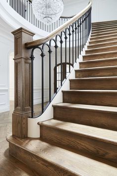 an elegant staircase with chandelier and wooden steps