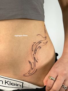 a woman's stomach with a tattoo on her lower half and the bottom part of her belly