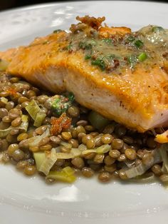 a white plate topped with fish and lentils