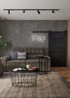 a living room filled with furniture and a play sign on the wall above it's coffee table