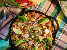 a pan filled with nachos and toppings on top of a table