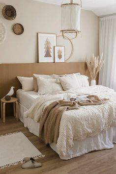 a bed with white linens and pillows in a bedroom next to a wooden floor