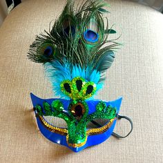 there is a mask with peacock feathers on it