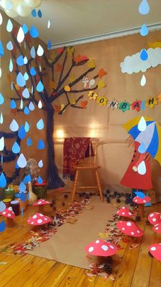 the room is decorated with paper umbrellas and raindrops on the floor, along with other decorations