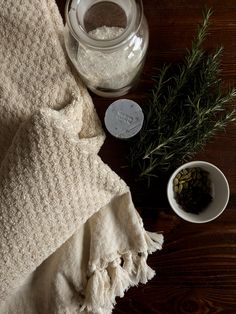 a table topped with two bowls filled with salt and herbs next to a jar of seasoning