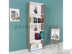 a white book shelf with books on it next to a blue wall and an easel