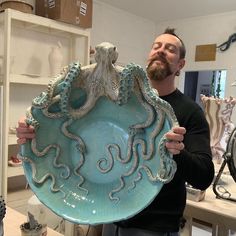 a man holding an octopus bowl in his hands